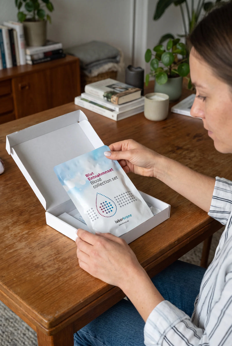Frau öffnet das Hormondiagnostik-Kit an einem Tisch